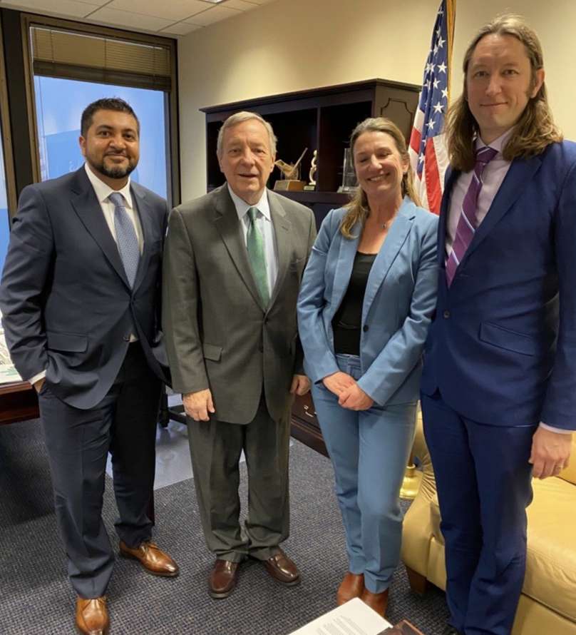 Group of four individuals in an office featuring Stemloop CEO: Khalid, K. Alam, Ph.D., US Senator: Richard J. Durbin (D-IL), Sera Young, and Stemloop Cofounder: Julius Lucks.
