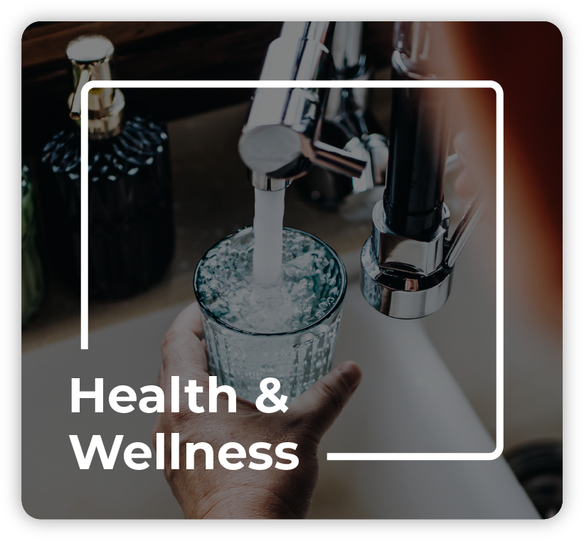 Hands using faucet to fill a glass of water from sink tap with text overlaid "Health & Wellness".